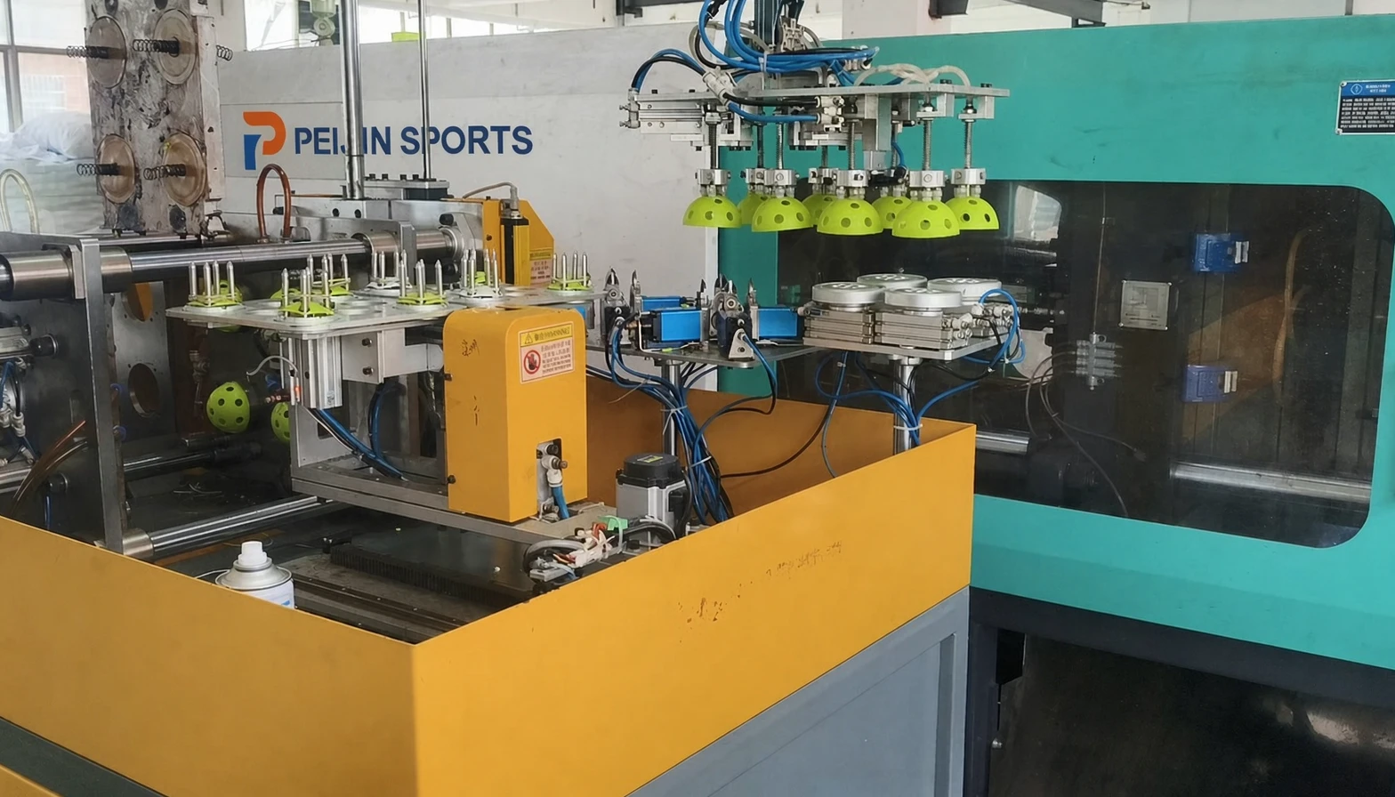 High speed automated injection molding machine producing 26-hole and 40-hole pickleball halves and indoor balls