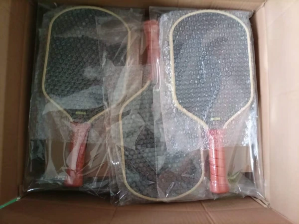 Packaging individual finished pickleball paddles into thick bubble bags to prevent scratches during transport