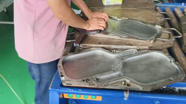 Technician loading pre-assembled carbon fiber paddle materials into high-precision steel hot press molds