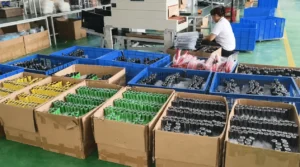 Rows of pickleball paddles with green, yellow and black grips packed in cartons and blue crates