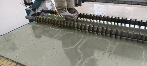Precision CNC machine cutting carbon fiber layers and honeycomb cores for custom pickleball paddle shapes